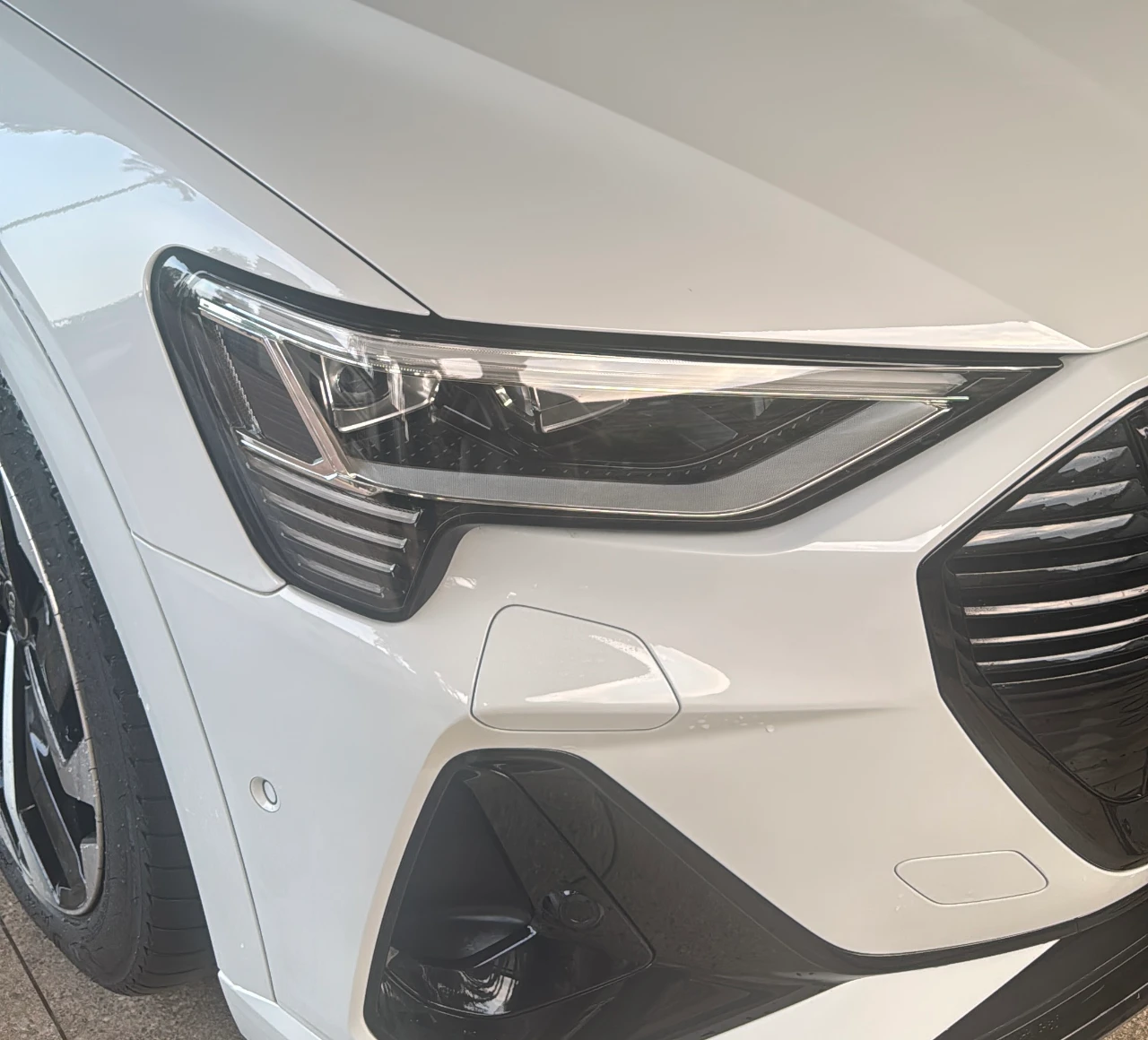 Close-up of a headlight on a white car